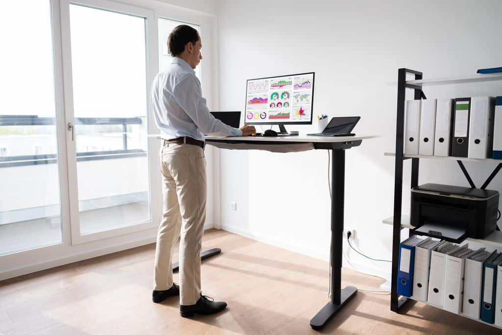 Homme travaille avec un bureau assis debout dans son bureau