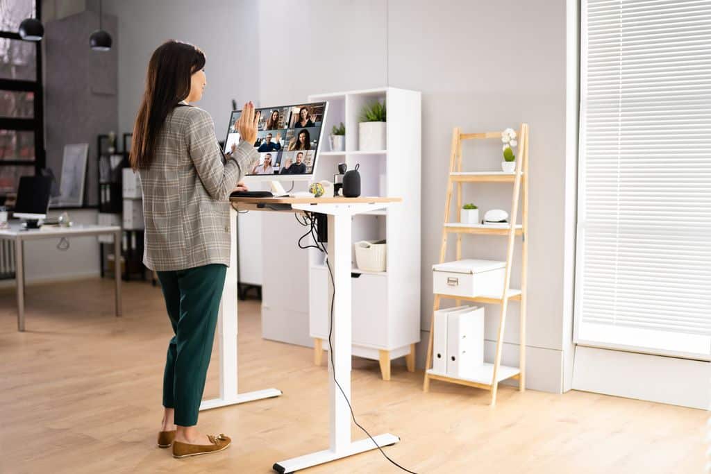 Femme debout face à son bureau assis debout pour une réunion